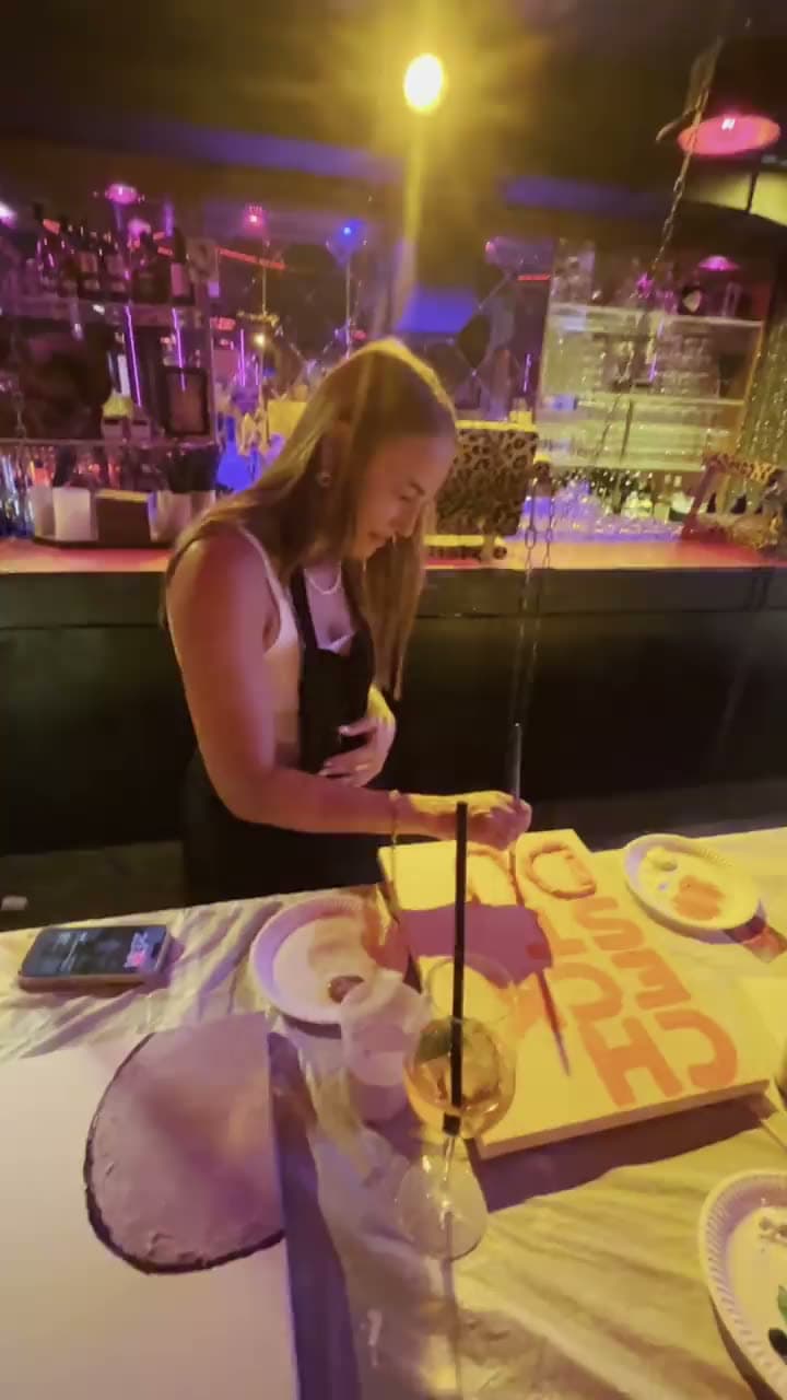 Eine Gästin bemalt eine Leinwand in einer bunten Bar